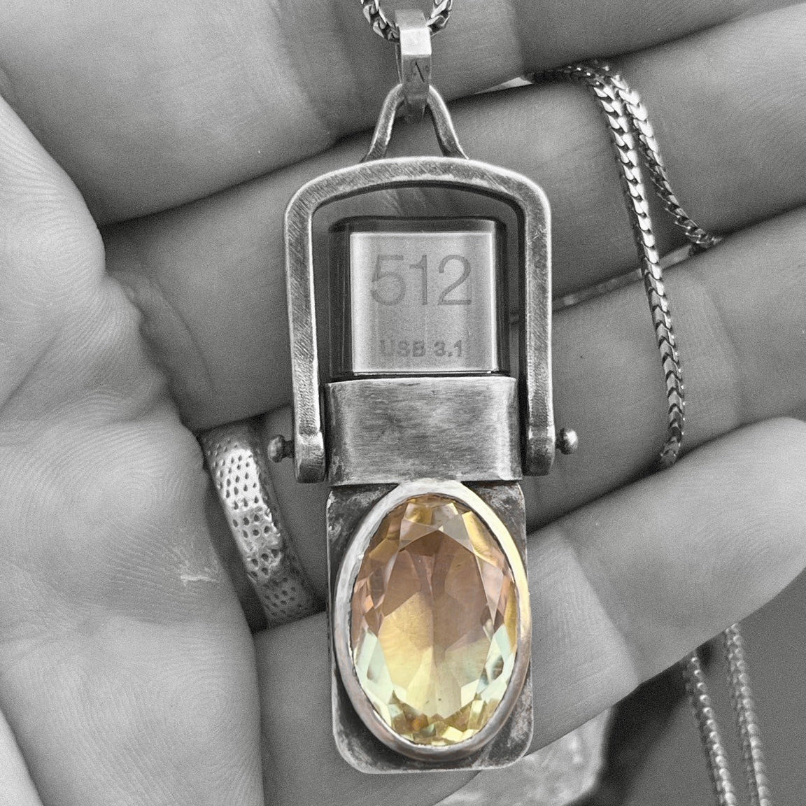 Hand holding the sterling silver USB Drives Necklace with champagne citrine, chain, and visible 512GB USB 3.1 drive.